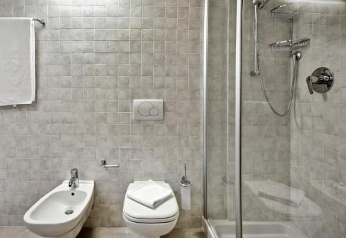 W łazience znajduje się prysznic, toaleta i umywalka. w obiekcie Rosa dei Venti - Lake view Apartments & Suites w mieście Bellano