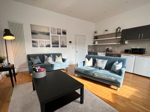 un soggiorno con 2 divani blu e un tavolo di Bouverie Bolthole a Folkestone