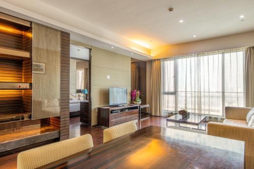 a living room with a couch and a television at Guangzhou Xing Yi International Apartment - Poly World Branch in Guangzhou