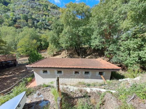 uma pequena casa com um telhado vermelho numa colina em Agricamping Ponteraggio n.1 em Dolceacqua