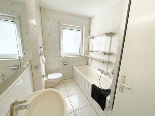 a bathroom with a tub and a toilet and a sink at Nice 2,5-Room Apartment in Untergruppenbach