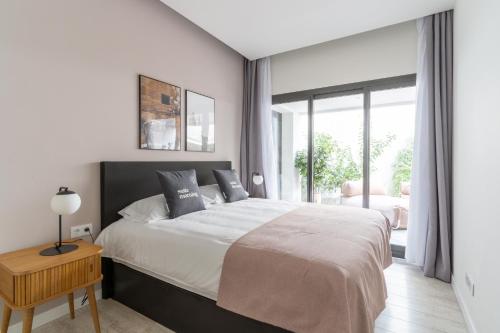 a white bedroom with a large bed and a window at limehome Barcelona Rector Triadó in Barcelona