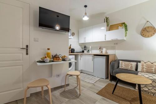 une cuisine et un salon avec une table et des chaises dans l'établissement Studio « le Bohème chic », à Nîmes