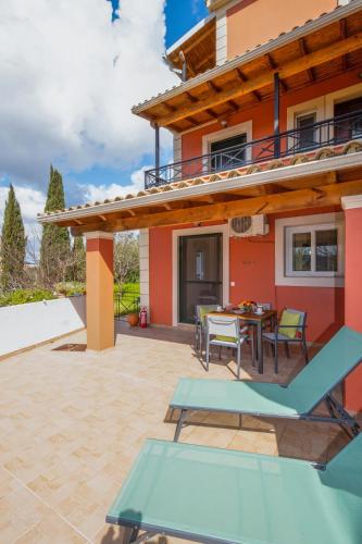 a patio with a table and chairs and a house at Kanali Hill Apartment in (( Agía Eleoúsa ))