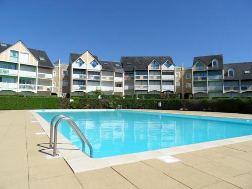 une piscine devant un grand immeuble d'appartements dans l'établissement REF 003 - Studio vue port Crouesty pour deux personnes résidence avec piscine, à Arzon