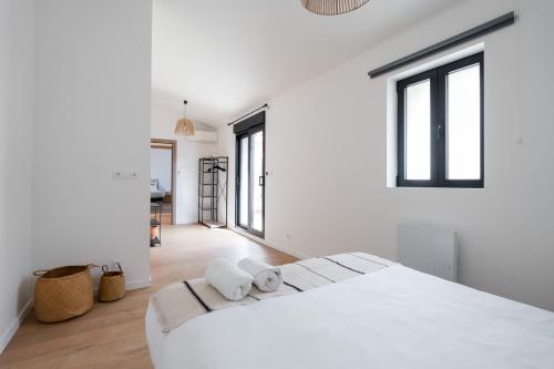 a white bedroom with a large white bed and windows at MaisonMars - La Maison du Parc 3 - Terrasse Parking in Marseille