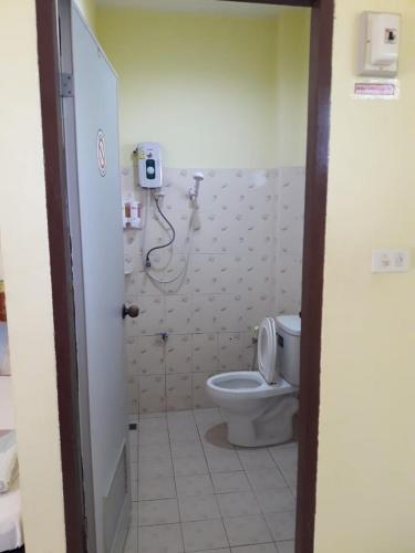 ein Bad mit WC und ein Telefon an der Wand in der Unterkunft ฮอมฮักรีสอร์ท in Chiang Kham