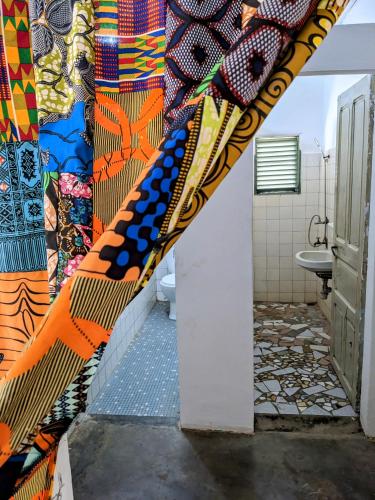 a bathroom with a colorful mural on the wall at Chambres d'hôtes - Chez maman Sêdjro in Porto-Novo