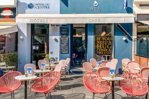 a row of tables and chairs in front of a restaurant at Hôtel Du Centre, un hôtel AMMI in Nice