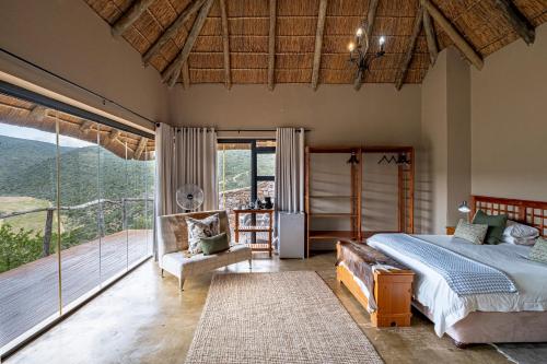 a bedroom with a bed and a balcony at Huntshoek Lodge in Grahamstown