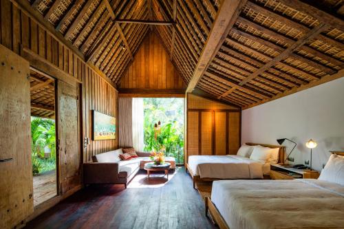 a bedroom with two beds and a couch in a room at The Asa Maia - Bespoke Wellness Resort in Uluwatu