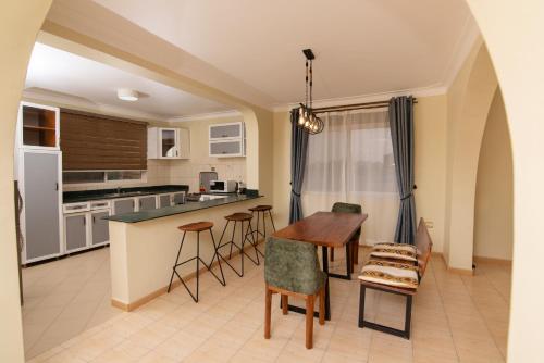 a kitchen with a table and chairs in a room at Olori Rentals in Kampala