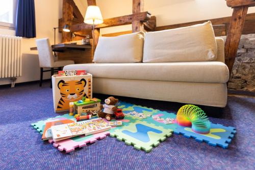 a living room with a couch and toys on the floor at Boutique-Hotel Rüden in Schaffhausen
