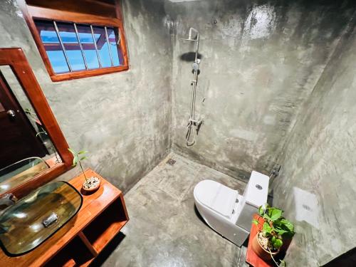 a bathroom with a sink and a toilet and a shower at Cozy Villa in Hikkaduwa