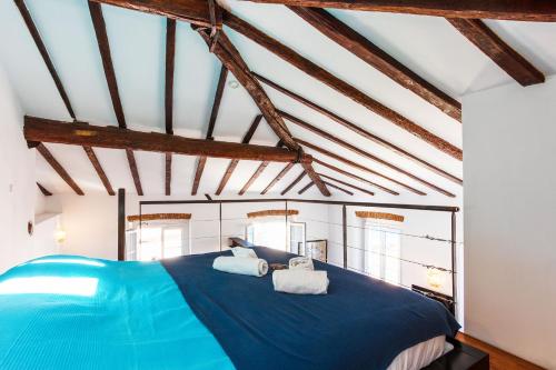 a bedroom with a blue bed with two towels at View on the Bay AP4294 By Riviera Holiday Homes in Villefranche-sur-Mer