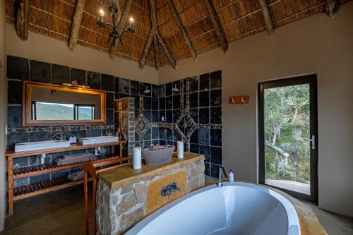 a bathroom with a tub and a sink and a mirror at Huntshoek Lodge in Grahamstown