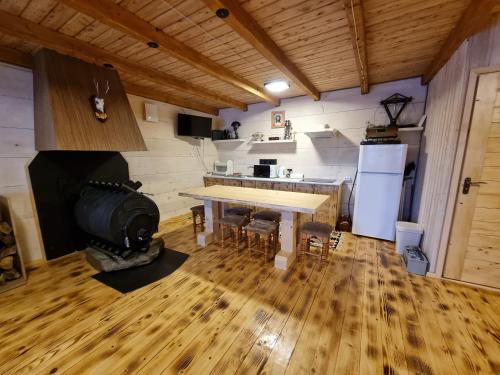 a kitchen with a table and a stove in a room at Vysoka brama дерев'яний будиночок з чаном in Oriv