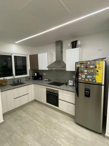 a kitchen with a stainless steel refrigerator and appliances at Estancia Nápoles, CANA BAY Hard Rock. in Punta Cana