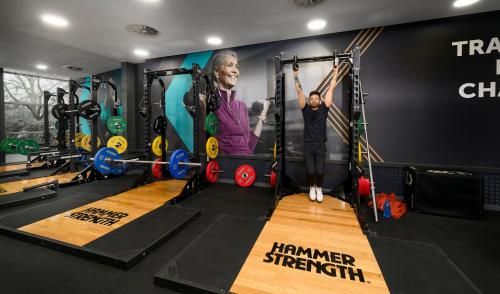 a man is standing in a gym with weights at Bisham Abbey National Sports Centre in Marlow