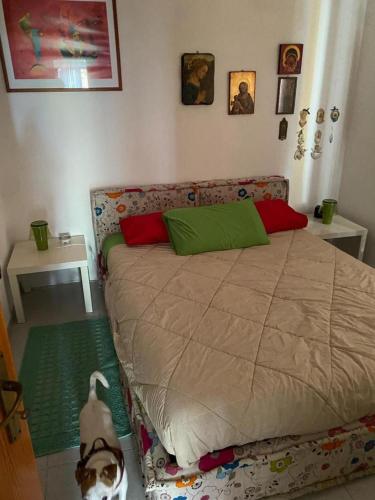 1 dormitorio con 1 cama con almohadas verdes y rojas en Casa nel Parco, en Cassano delle Murge