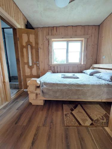a bedroom with a bed and a window in it at Котеджі Цімбори in Yablunytsya