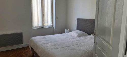 a bedroom with a white bed with a window at Résidence Auger in Bourges