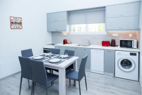 a kitchen with a table and chairs and a washing machine at Sunny and minimal apt in Glyfada with 3 bdrm in Athens