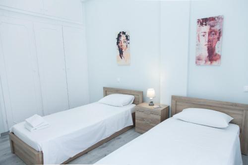 2 camas en una habitación con paredes blancas en Sunny and minimal apt in Glyfada with 3 bdrm, en Atenas