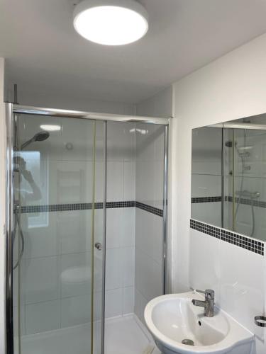 baño blanco con ducha y lavamanos en Large Bed in a luxuriously furnished Guests-Only home, Own Bathroom, Free WiFi, West Thurrock, en Grays