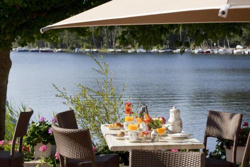 une table avec de la nourriture à côté d'une masse d'eau dans l'établissement Chambres 