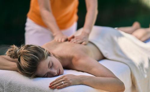 a woman is getting a massage on a towel at EurothermenResort Bad Hall - Hotel Miraverde in Bad Hall
