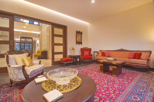 a living room filled with furniture on top of a rug at Stayvista at Ekant - Exquisite 3BHK with Private Pool in Amritsar in Amritsar