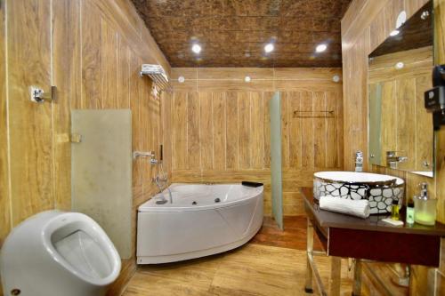 baño con bañera grande y lavamanos en Dalhousie valley Resort By DLS Hotels en Banikhet