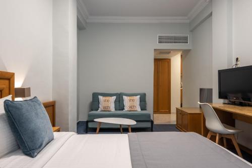a hotel room with a bed and a tv and a couch at Poseidonio in Piraeus