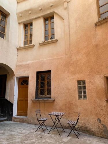 deux chaises et une table devant un bâtiment dans l'établissement Charmant Studio Hyper Centre Proche Cathédrale, à Albi