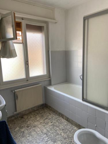 een badkamer met een bad, een toilet en een wastafel bij Apartment Rue Centrale in Crans-Montana