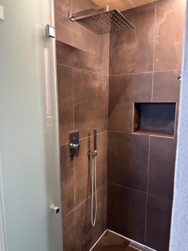 a bathroom with a shower with brown tile at A Casa di Clara in Trapani