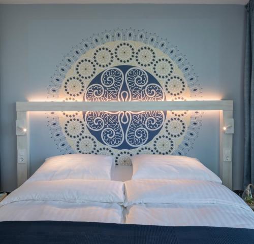 a bedroom with a bed with a blue and white wall at Falkensteiner Club Funimation Borik in Zadar