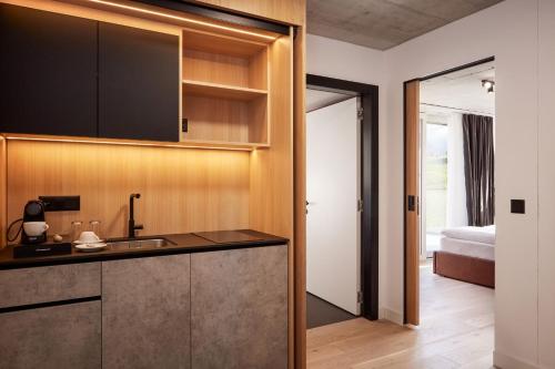 a kitchen with a sink and a bed in a room at Tailormade Hotel RIGIBLICK Küssnacht in Küssnacht