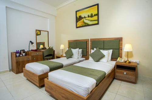 una camera d'albergo con 2 letti e una scrivania di La Villa Palace Hotel a Doha
