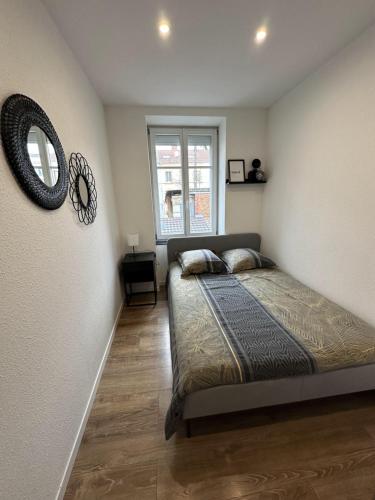 een slaapkamer met een bed en een spiegel aan de muur bij # Le 2 # Très Beau T3 1er étage tout confort, neuf, Mulhouse centre in Mulhouse