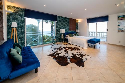 un soggiorno con letto e divano blu di Beautiful Villa with amazing Monte Carlo & Sea View a La Turbie