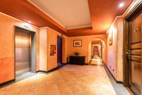 a hallway of a building with orange walls and tile floors at Hotel Arbatasar in Àrbatax