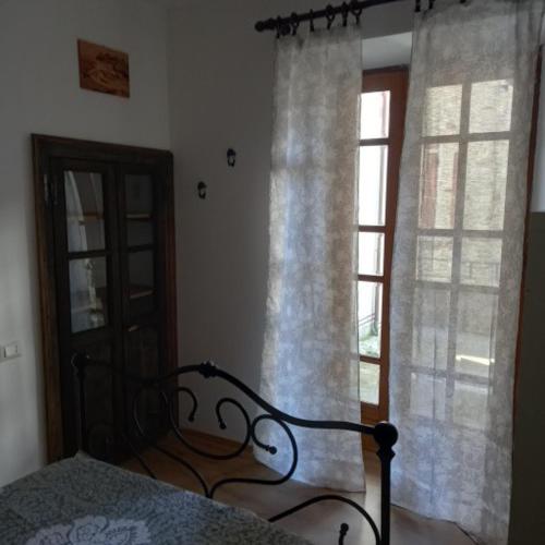a bedroom with a bed and a window with curtains at Da Linda in Guinadi