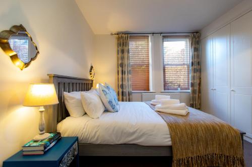1 dormitorio con cama, lámpara y ventana en Carr Croft Lodge - Ilkley Centre, en Ilkley