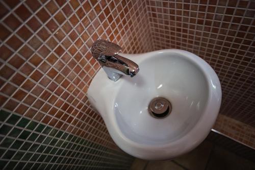 a white sink in a tiled bathroom at Apartments Lavric in Nova Vas