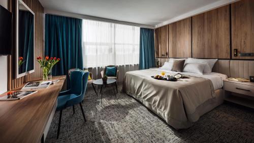 a hotel room with a bed and a desk at Grand Hotel Zagreb in Zagreb