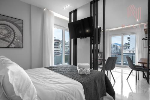 a bedroom with a bed with a table and chairs at Hermes Suites, Agia Sofia, Nilie Hospitality MGMT in Thessaloniki