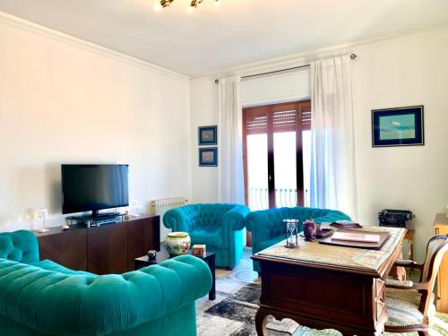 a living room with blue chairs and a television at Maison belle Vue in Taormina