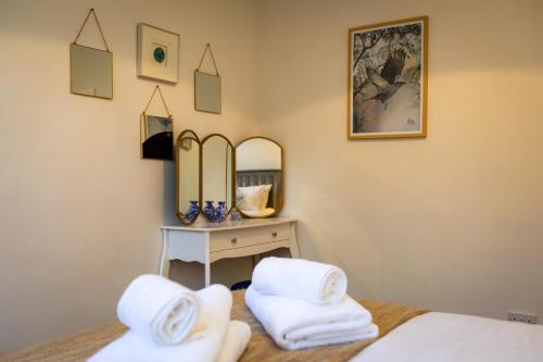 a bedroom with two beds and a mirror at Carr Croft Lodge - Ilkley Centre in Ilkley